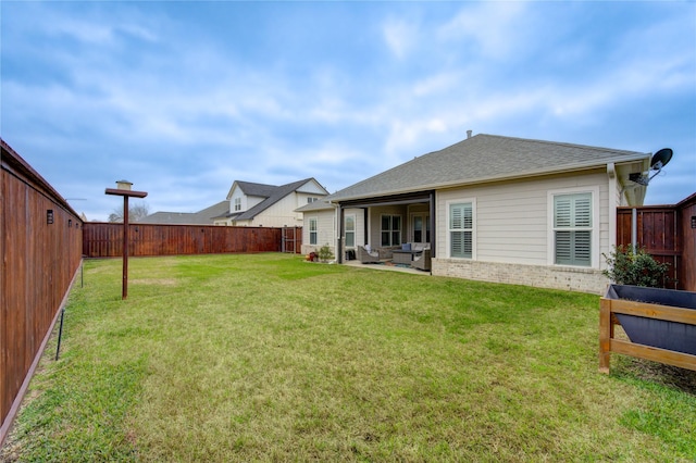 back of house featuring a patio, a fenced backyard, roof with shingles, a yard, and brick siding