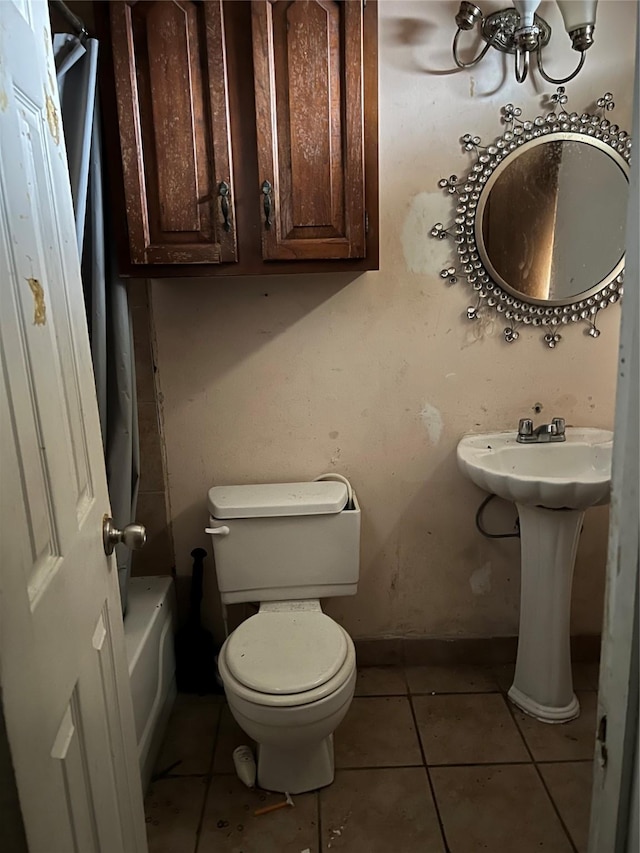 full bathroom featuring baseboards, a bathtub, toilet, and tile patterned floors