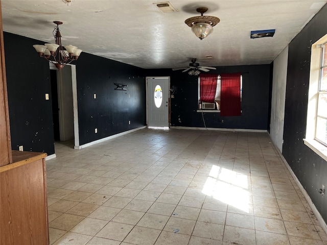 interior space featuring cooling unit, visible vents, baseboards, and ceiling fan with notable chandelier