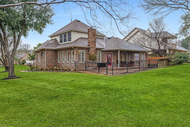 back of house featuring a chimney, roof with shingles, fence, a yard, and brick siding