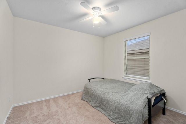 bedroom featuring baseboards, a ceiling fan, and light colored carpet