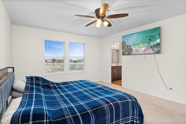 carpeted bedroom with connected bathroom, a ceiling fan, and baseboards