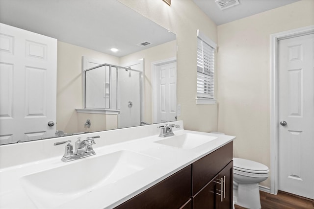 full bath featuring toilet, a stall shower, visible vents, and a sink