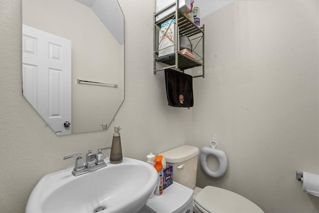half bathroom featuring a sink and toilet