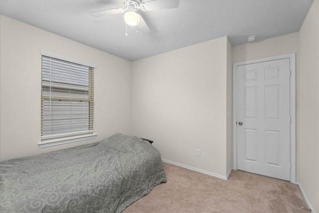 bedroom featuring light carpet, ceiling fan, and baseboards