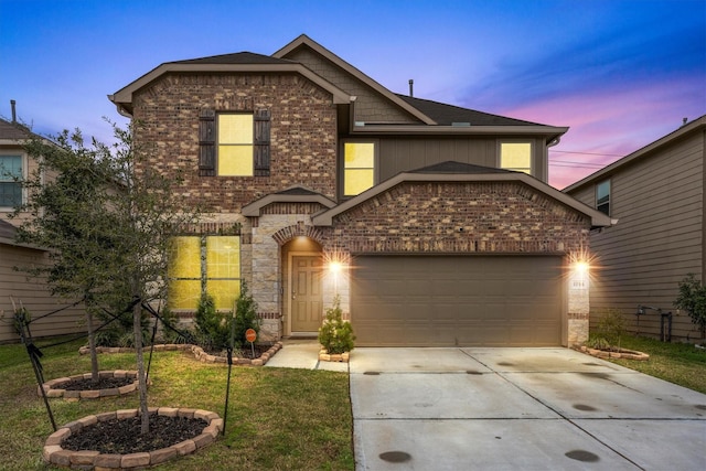 view of front of home with an attached garage, a yard, driveway, and brick siding