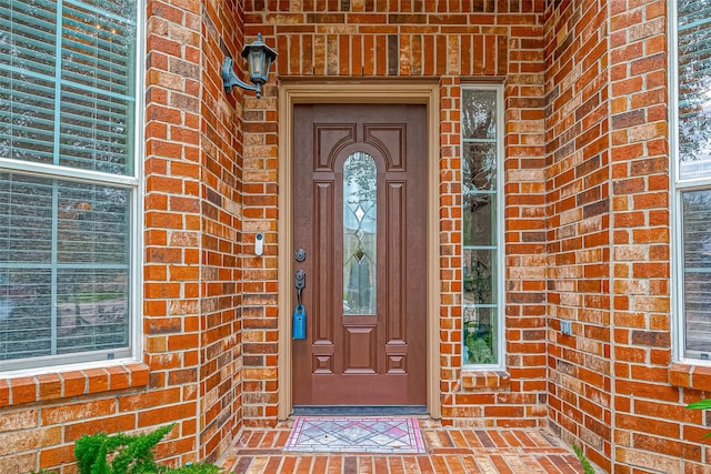 property entrance featuring brick siding