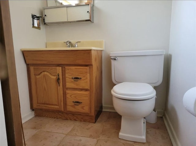 half bath featuring toilet, baseboards, and vanity