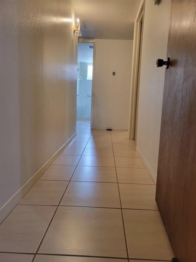 hall with baseboards and light tile patterned flooring