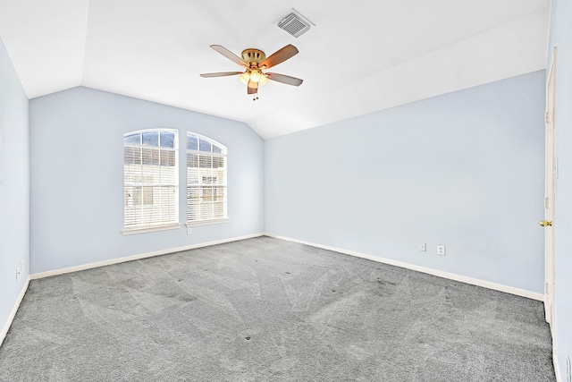 spare room with carpet, visible vents, a ceiling fan, vaulted ceiling, and baseboards