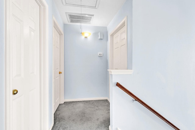 hall with visible vents, an upstairs landing, baseboards, carpet, and attic access