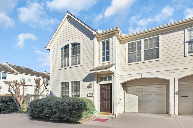 view of front of house featuring an attached garage, driveway, and fence