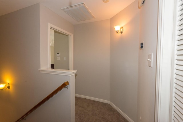 corridor with visible vents, carpet flooring, an upstairs landing, and baseboards