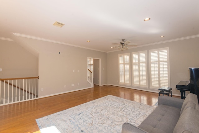 living room featuring baseboards, ornamental molding, and wood finished floors