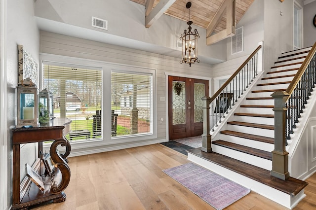 foyer entrance featuring beamed ceiling, stairway, light wood-type flooring, and wood ceiling