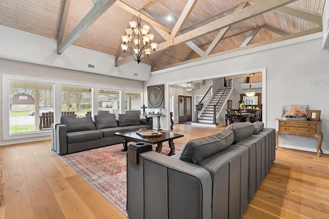 living room featuring light wood finished floors, visible vents, wooden ceiling, stairway, and a notable chandelier