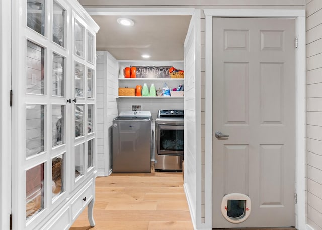 interior space with recessed lighting, laundry area, wood walls, light wood-style floors, and washer and clothes dryer