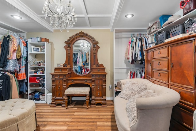 spacious closet featuring a chandelier, coffered ceiling, and wood finished floors