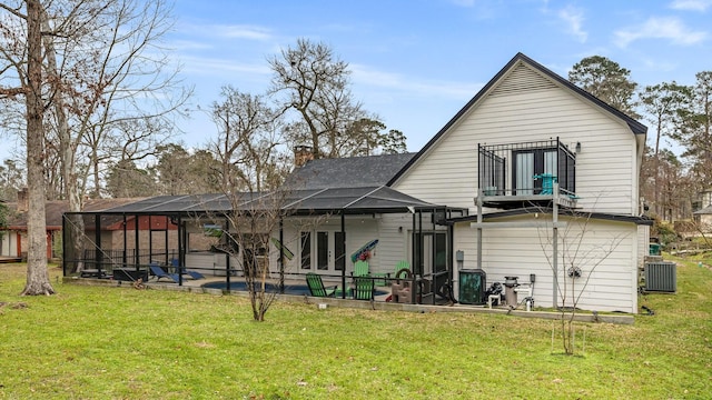 rear view of property with a lanai, a yard, french doors, and central air condition unit