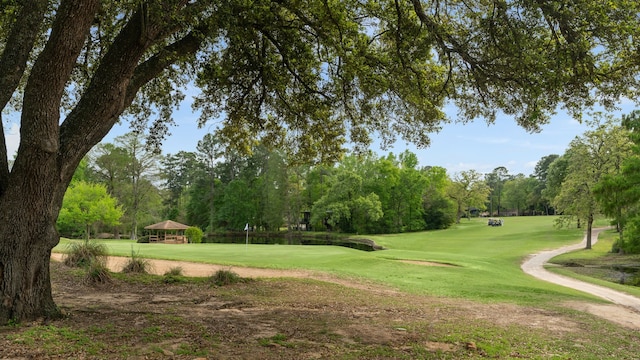 view of property's community with view of golf course, a yard, and a gazebo