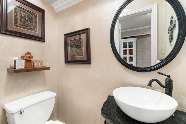 bathroom featuring ornamental molding, a sink, and toilet