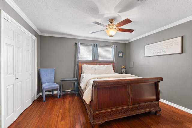 bedroom with baseboards, dark wood finished floors, ceiling fan, ornamental molding, and a closet