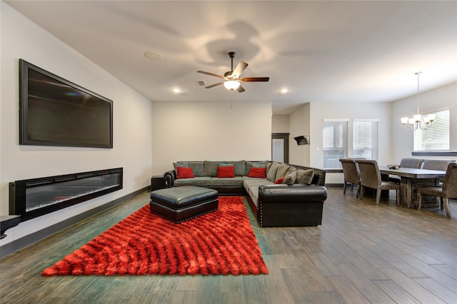 living area with recessed lighting, ceiling fan with notable chandelier, dark wood-style flooring, visible vents, and a glass covered fireplace