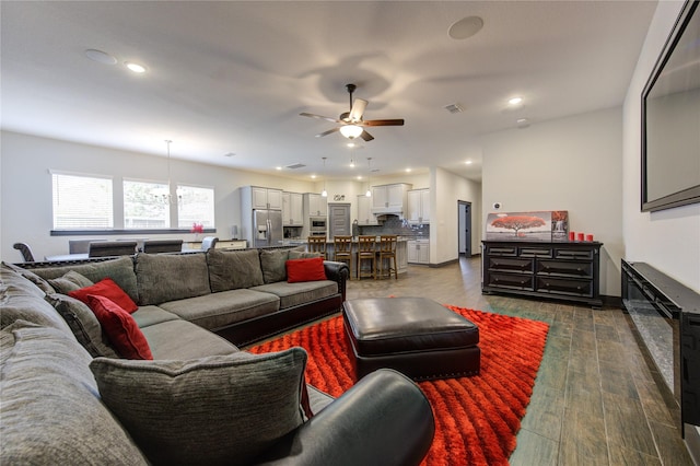 living room with dark wood-style floors, ceiling fan, visible vents, and recessed lighting