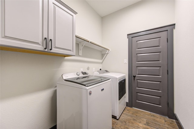 laundry room with dark wood-style floors, washer and dryer, and cabinet space