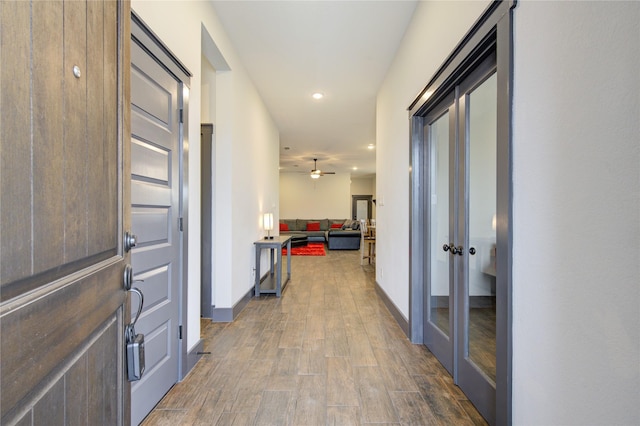 hallway featuring recessed lighting, baseboards, and wood finished floors