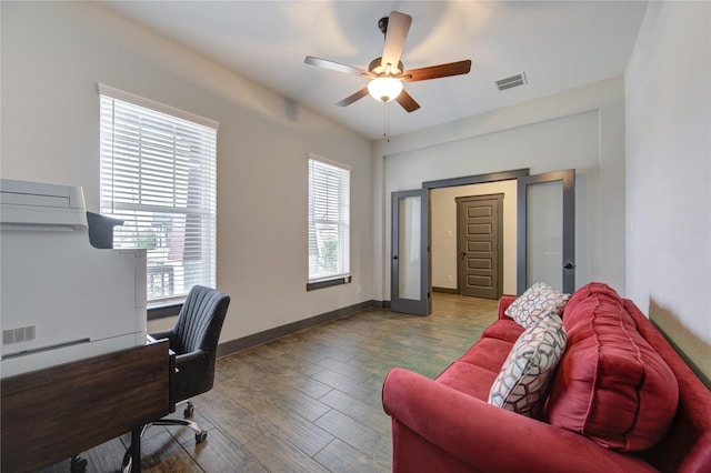 office area with dark wood-style floors, baseboards, visible vents, and a ceiling fan