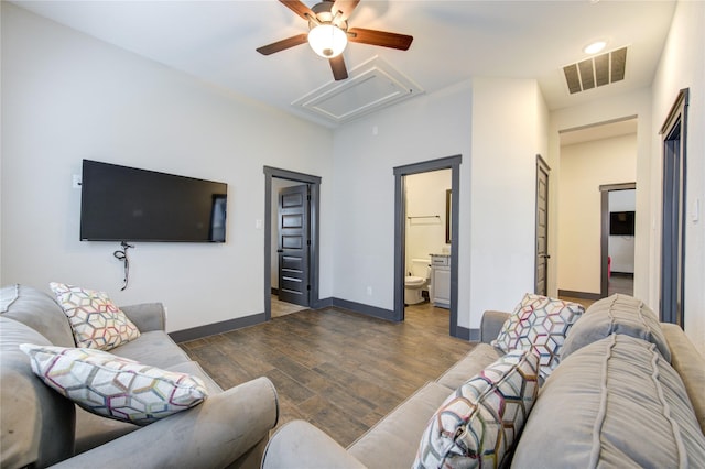 living area featuring ceiling fan, dark wood-type flooring, visible vents, baseboards, and attic access