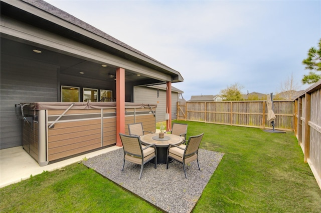 view of yard featuring outdoor dining space, a patio area, a fenced backyard, and a hot tub