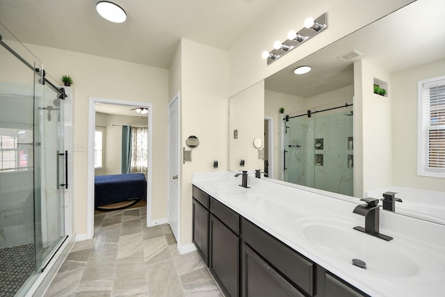 bathroom with a shower stall, double vanity, a sink, and connected bathroom