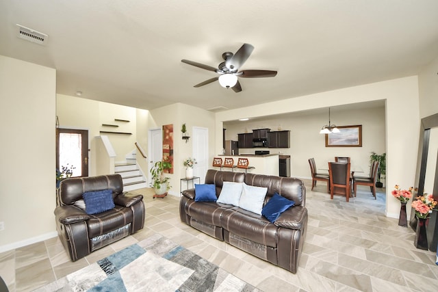 living area with visible vents, ceiling fan, baseboards, and stairs