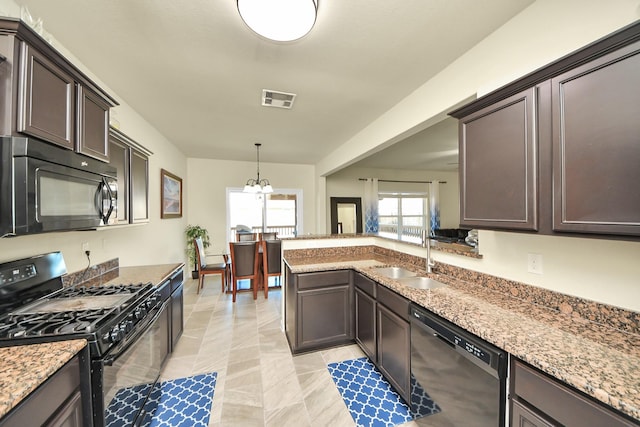 kitchen with dark brown cabinetry, a sink, visible vents, hanging light fixtures, and black appliances