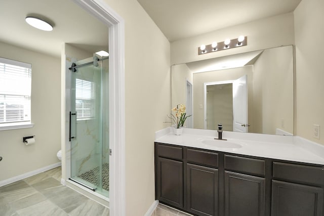 bathroom featuring toilet, a marble finish shower, baseboards, and vanity