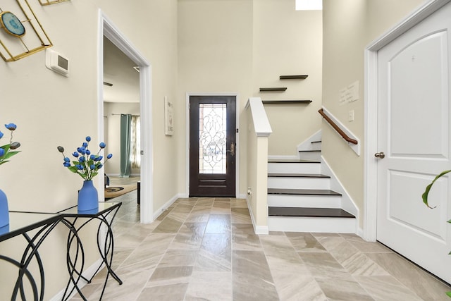 foyer entrance featuring stairs and baseboards