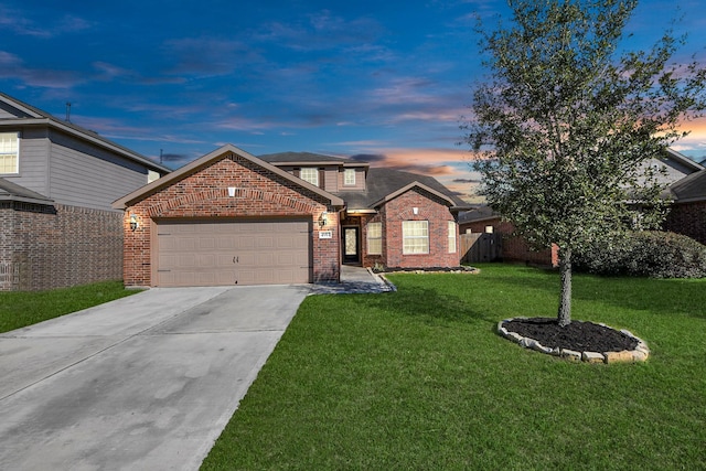 traditional home with an attached garage, brick siding, fence, driveway, and a front lawn