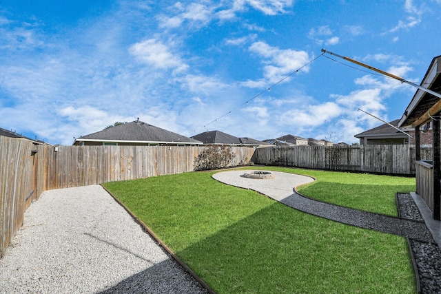 view of yard featuring a fenced backyard and a fire pit