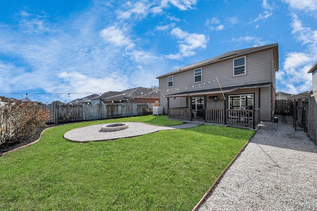 rear view of house featuring an outdoor fire pit, a lawn, a fenced backyard, and a patio