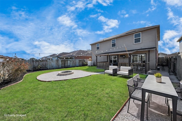 rear view of property with an outdoor living space with a fire pit, a yard, a patio area, and a fenced backyard