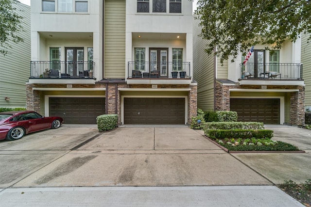 multi unit property with a garage, concrete driveway, and stucco siding