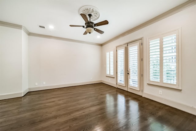 empty room with baseboards, visible vents, ornamental molding, and dark wood-style flooring