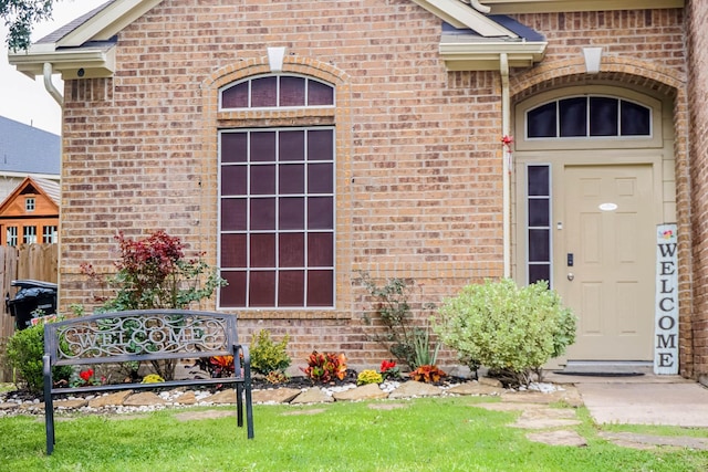 view of exterior entry featuring brick siding