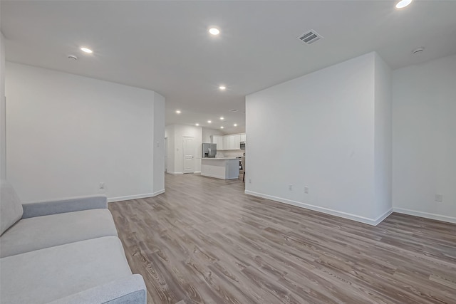 living area featuring recessed lighting, visible vents, light wood-style flooring, and baseboards