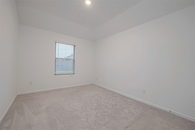 unfurnished room with baseboards and light colored carpet