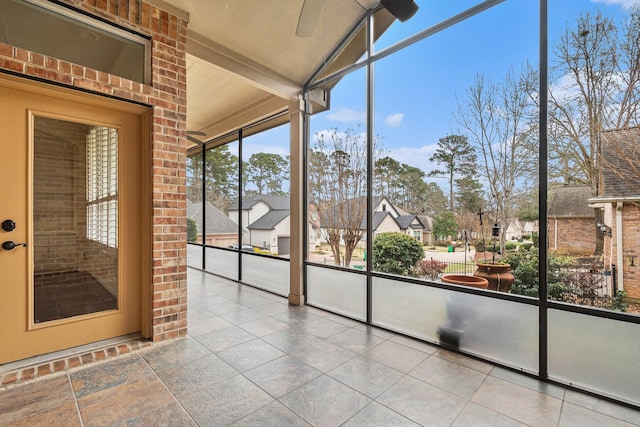 unfurnished sunroom featuring lofted ceiling and a residential view