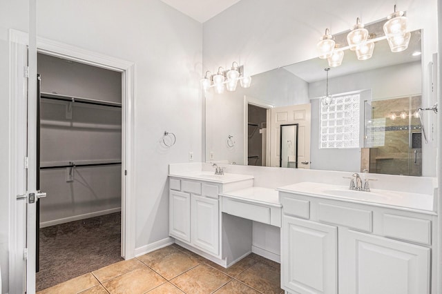 full bathroom with a walk in closet, double vanity, a sink, a tile shower, and tile patterned floors