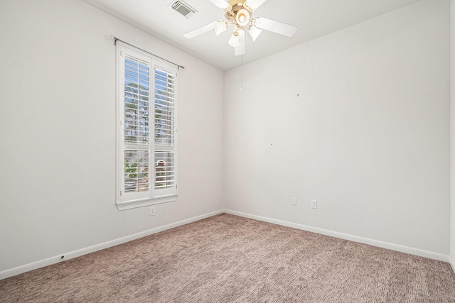 spare room with carpet floors, visible vents, baseboards, and a ceiling fan